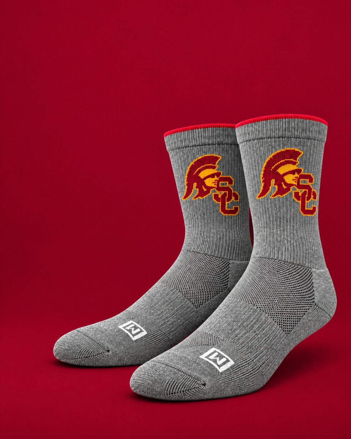 Grey performance socks with the USC Trojans logo on a cardinal red background